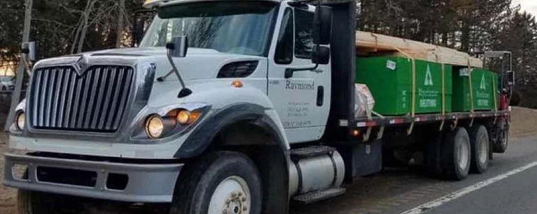 A Raymond Hardware delivery truck loaded with lumber, out on a job-site run